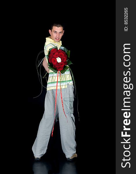 Portrait of a groom showing the wedding bouquet of red and white roses on black background, studio shot. Portrait of a groom showing the wedding bouquet of red and white roses on black background, studio shot