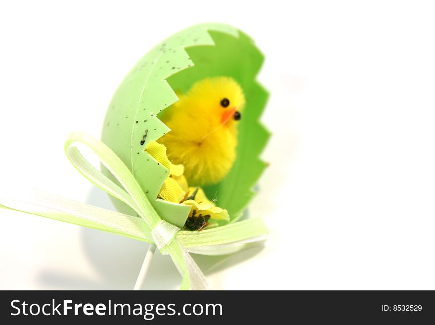 Yellow toy easter chick hatching out of an egg shell