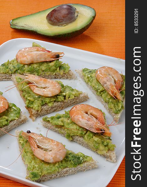 Sandwich with avocado and seafood on plate