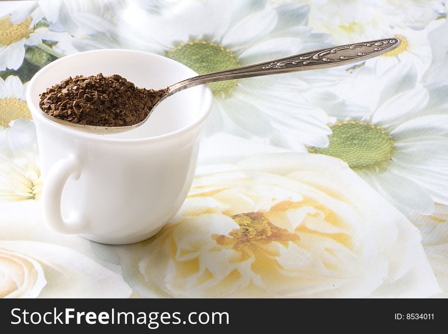 White cup and spoon with instant coffee