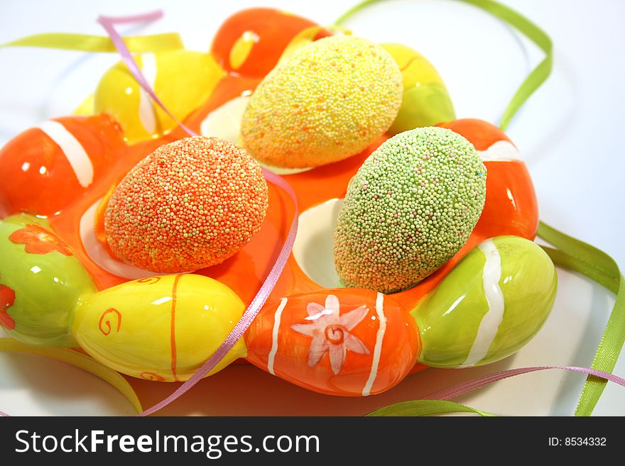 Egg shaped dish holding colorful Easter eggs
