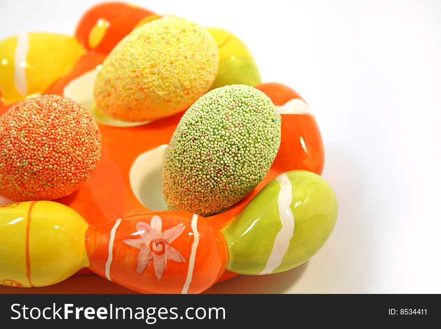 Egg shaped dish holding colorful Easter eggs