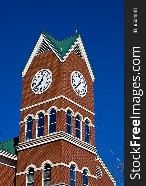 A beautiful brick tower with a clock against blue sky. A beautiful brick tower with a clock against blue sky