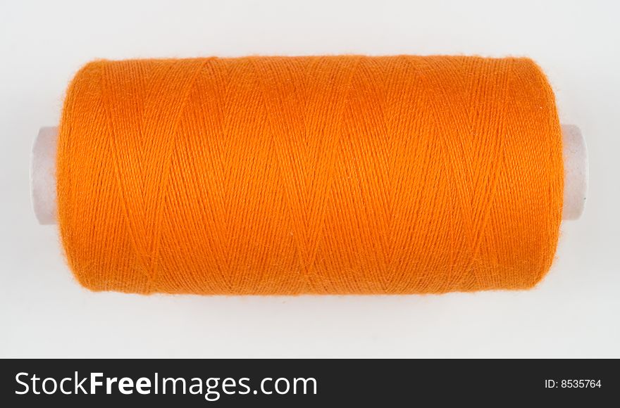 Close up of orange sewing spool