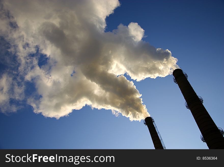 Smoke from a pipe on a background of the light-blue sky. Smoke from a pipe on a background of the light-blue sky.