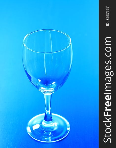 An empty wine glass in blue background.