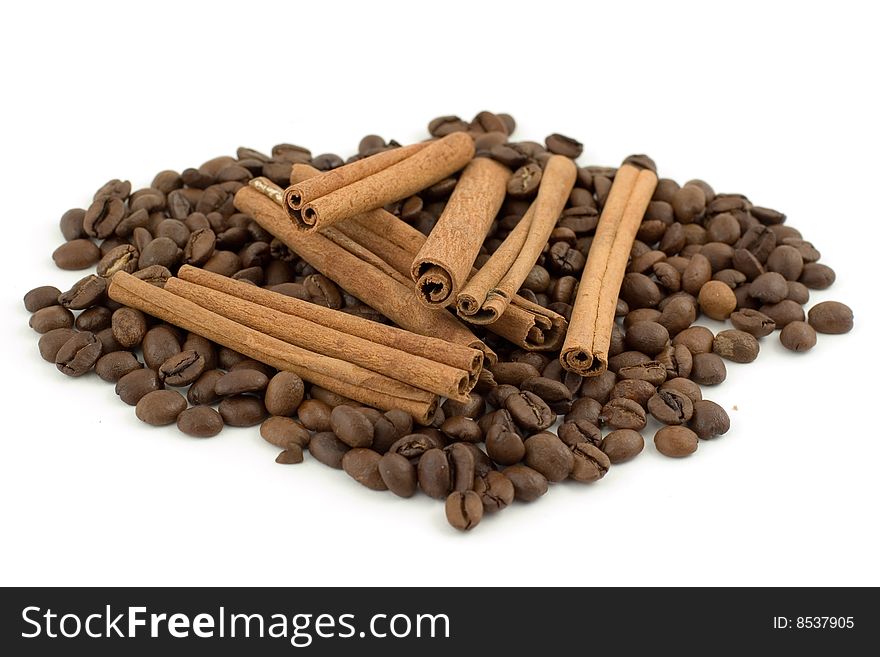 A pile of coffee beans with cinnamon sticks isolated on white background