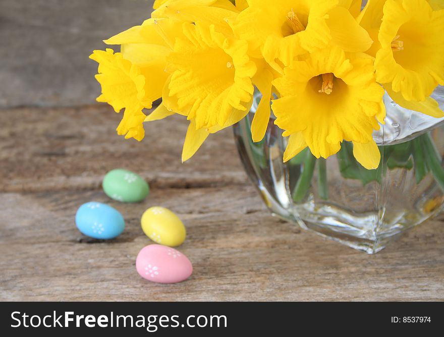 Daffodils in a vase with fake Easter eggs on the side to celebrate the holiday.  Used a selective focus and shallow depth of field. Daffodils in a vase with fake Easter eggs on the side to celebrate the holiday.  Used a selective focus and shallow depth of field.