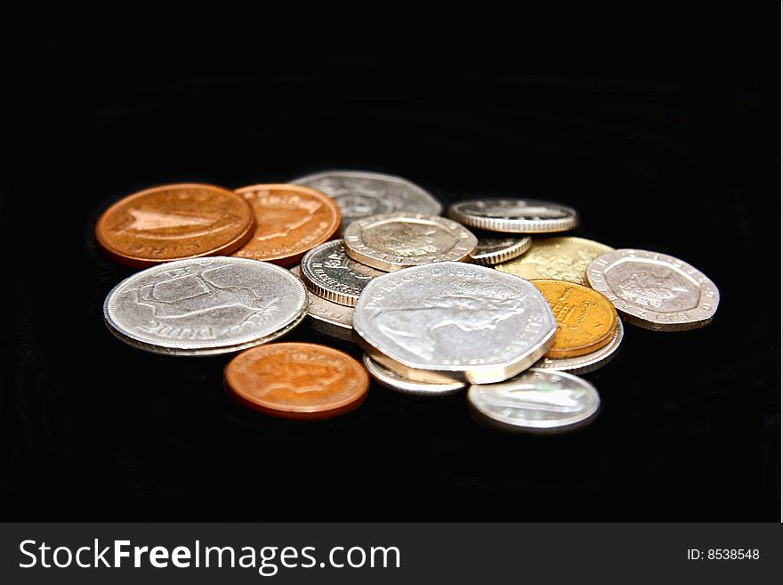 Assorted coins scattered on a black background