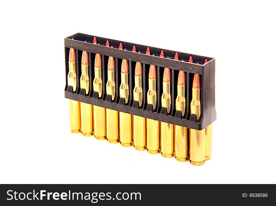 Gold bullets with red tips in holder on white