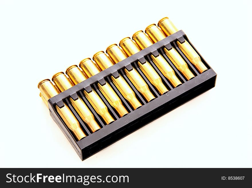 Gold bullets with red tips in holder on white