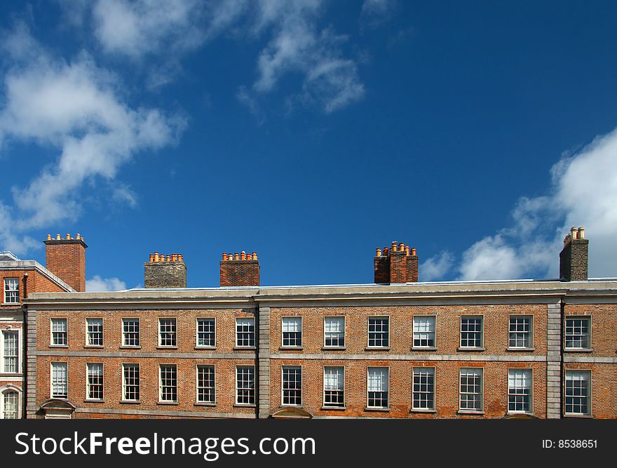 Red brick Irish building front with row of chimney on the rooftop. Red brick Irish building front with row of chimney on the rooftop
