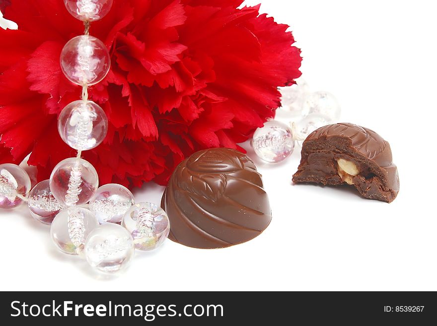 Red flower and black chocolate on white background. Red flower and black chocolate on white background