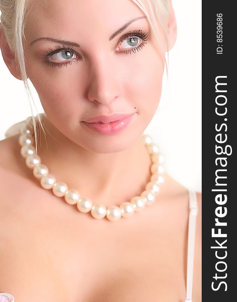 Portrait of the beautiful blonde with a pearl beads on a neck. Portrait of the beautiful blonde with a pearl beads on a neck