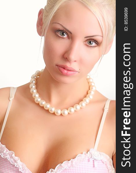 Portrait of the beautiful blonde with a pearl beads on a neck. Portrait of the beautiful blonde with a pearl beads on a neck