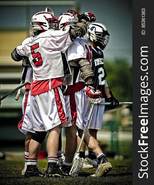 Group of male lacrosse players hugging as they celebrated a goal or win. Group of male lacrosse players hugging as they celebrated a goal or win.