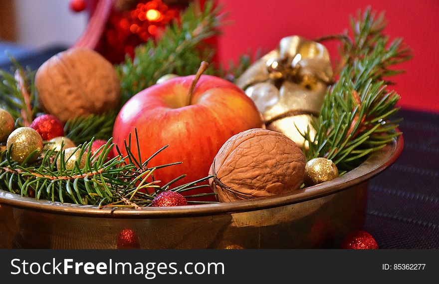 Christmas centerpiece in bowl with pine boughs, apple, walnuts and colorful ornaments. Christmas centerpiece in bowl with pine boughs, apple, walnuts and colorful ornaments.