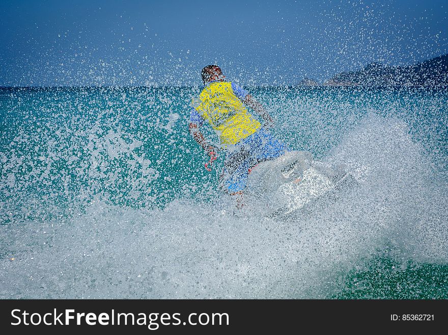 Man In Yellow Shirt Using Personal Watercraft