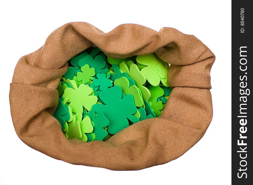 Bag of craft shamrocks on white background.