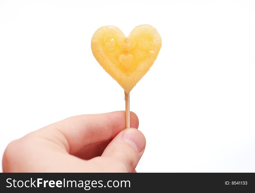 Hand with caramel candy on stick as a Valentine treat on white background isolated. Hand with caramel candy on stick as a Valentine treat on white background isolated