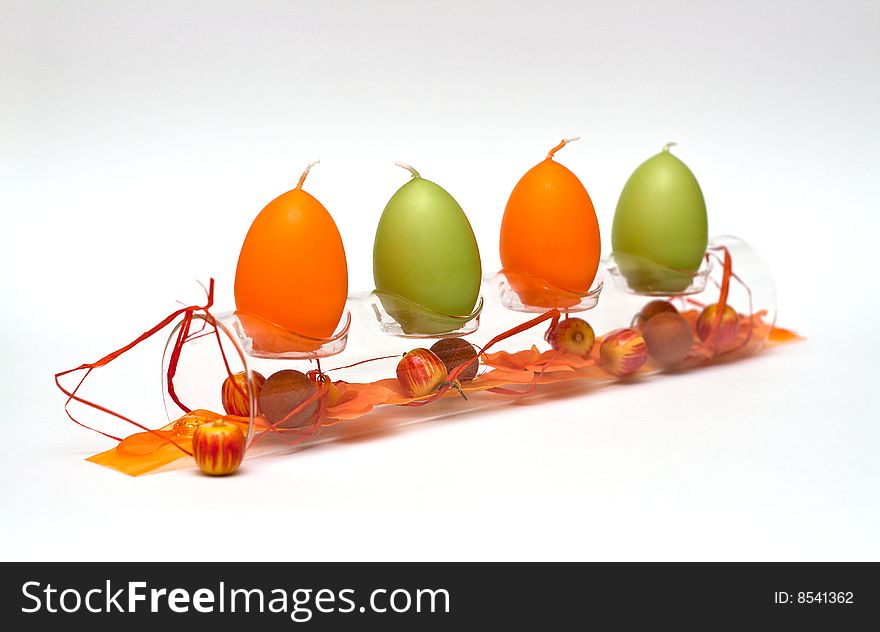 A composition of a glass tube with egg formed candles and a bit of spring feeling for easter. A composition of a glass tube with egg formed candles and a bit of spring feeling for easter.