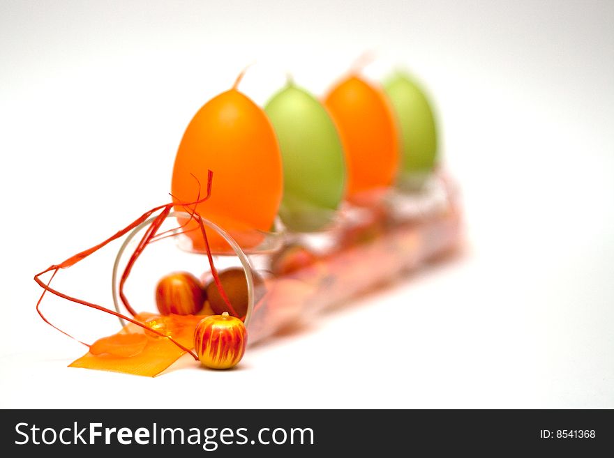 A composition of a glass tube with egg formed candles and a bit of spring feeling for easter. A composition of a glass tube with egg formed candles and a bit of spring feeling for easter.