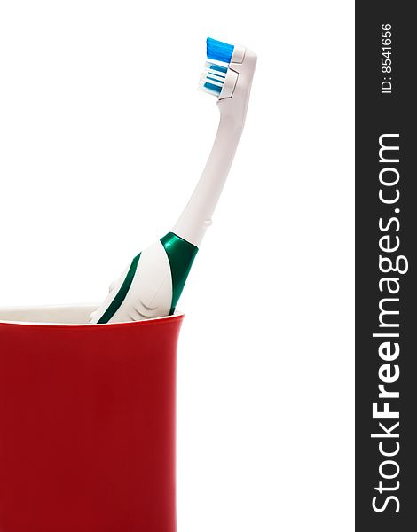 Toothbrush in a red glass on a white background