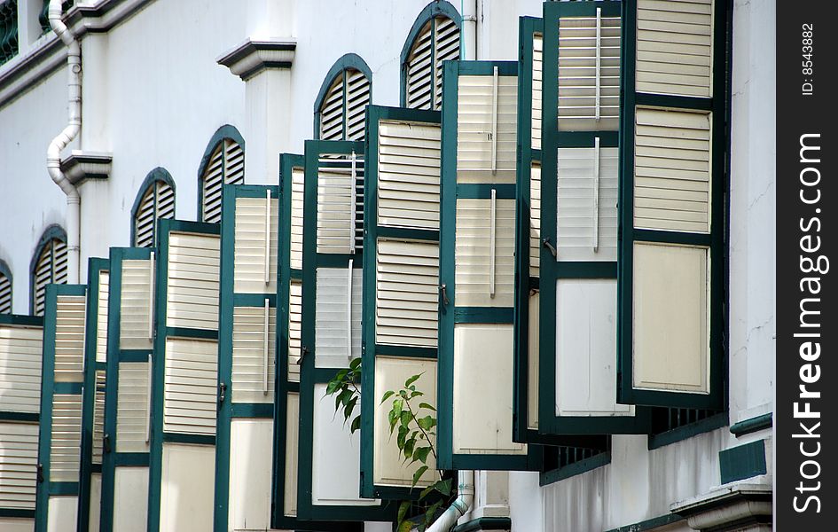 A row of louvered cream and green coloured shutters adorn a finely restored Telok Ayer Street house in the Chinatown district of Singapore - Lee Snider Photo. A row of louvered cream and green coloured shutters adorn a finely restored Telok Ayer Street house in the Chinatown district of Singapore - Lee Snider Photo.