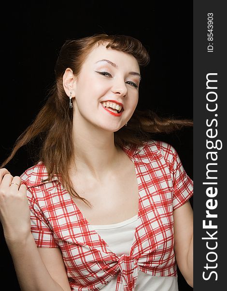 Pretty retro-style woman touching her hair, smiling and looking up over dark background. Pretty retro-style woman touching her hair, smiling and looking up over dark background