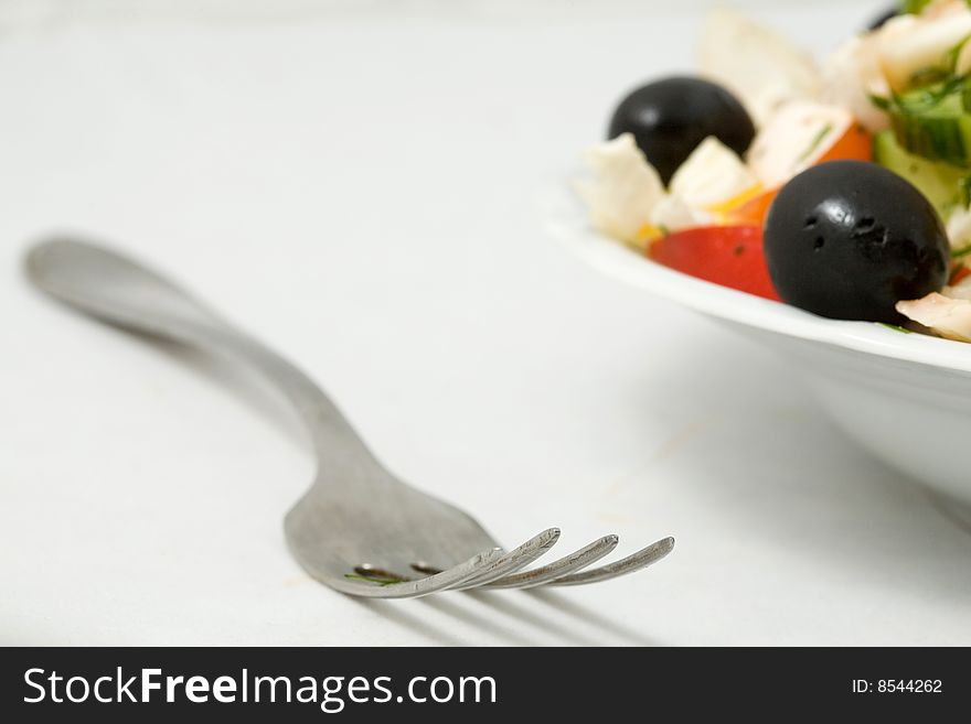 Stock photo: an image of a fork and a plate of tasty salad. Stock photo: an image of a fork and a plate of tasty salad