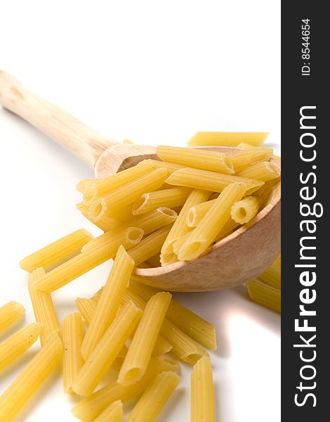 Raw italian macaroni in wooden spoon on white background