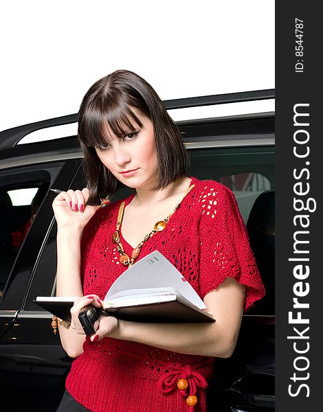 Young businesswomen with notebook stand by car. Young businesswomen with notebook stand by car