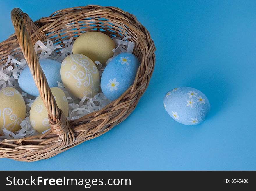 Easter eggs with basket on blue background