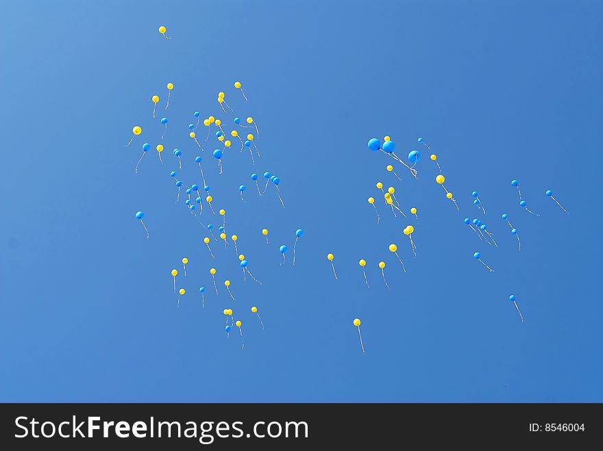 Blue and yellow balloons fly