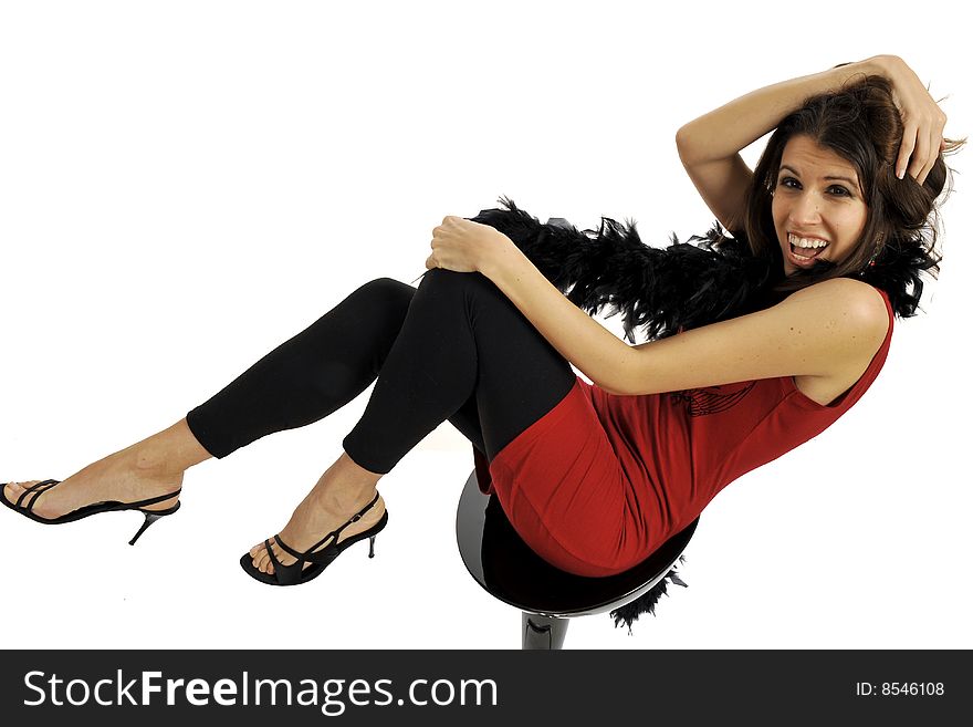 Elegant woman in elegant party wear, red dress and black boa, having fun and posing on a black chair. Isolated on white. Elegant woman in elegant party wear, red dress and black boa, having fun and posing on a black chair. Isolated on white