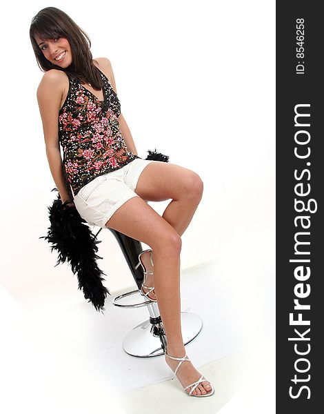 Portrait of a young lovely woman with beautiful smile and bright hazel eyes, wearing a black boa and white shorts and sandals on white background. Portrait of a young lovely woman with beautiful smile and bright hazel eyes, wearing a black boa and white shorts and sandals on white background