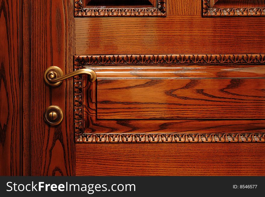 Brass door handle on the wooden classic door, ancient looky. Brass door handle on the wooden classic door, ancient looky