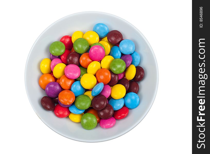 Close-up of colored candy in a bowl, isolated on a white background