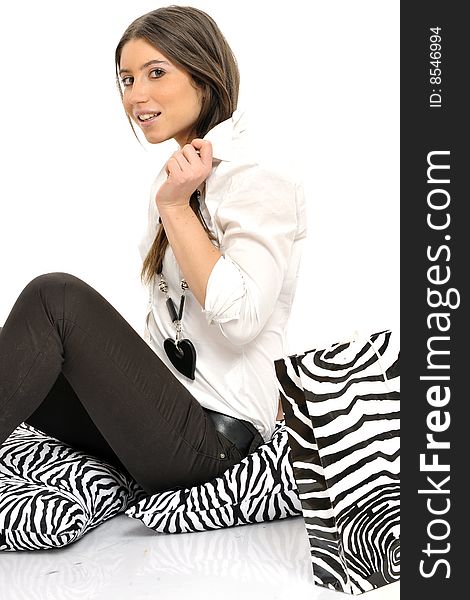Attractive young lady in black and white business clothing and accessories, zebra pillows and bag, isolated on white. Attractive young lady in black and white business clothing and accessories, zebra pillows and bag, isolated on white