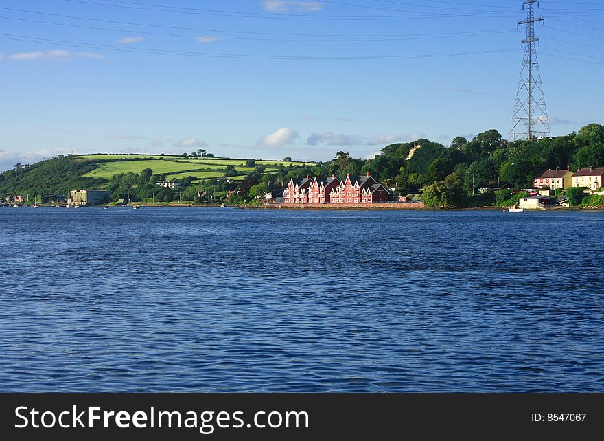 Landscape with mansion near sea shore green fields and power line