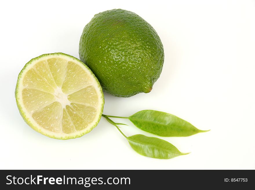Two green lemons and leaf. Two green lemons and leaf
