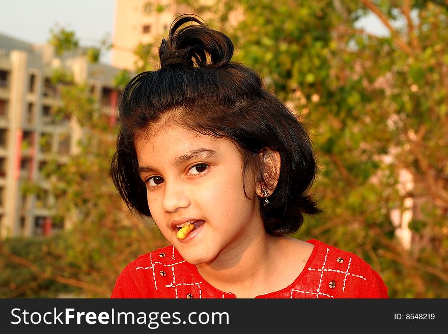 A nice and beautiful Indian girl eating something. A nice and beautiful Indian girl eating something.