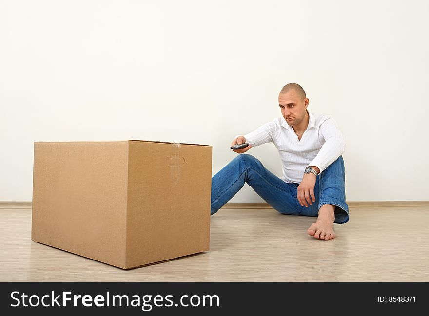 The man sits with the panel opposite to a box. The man sits with the panel opposite to a box