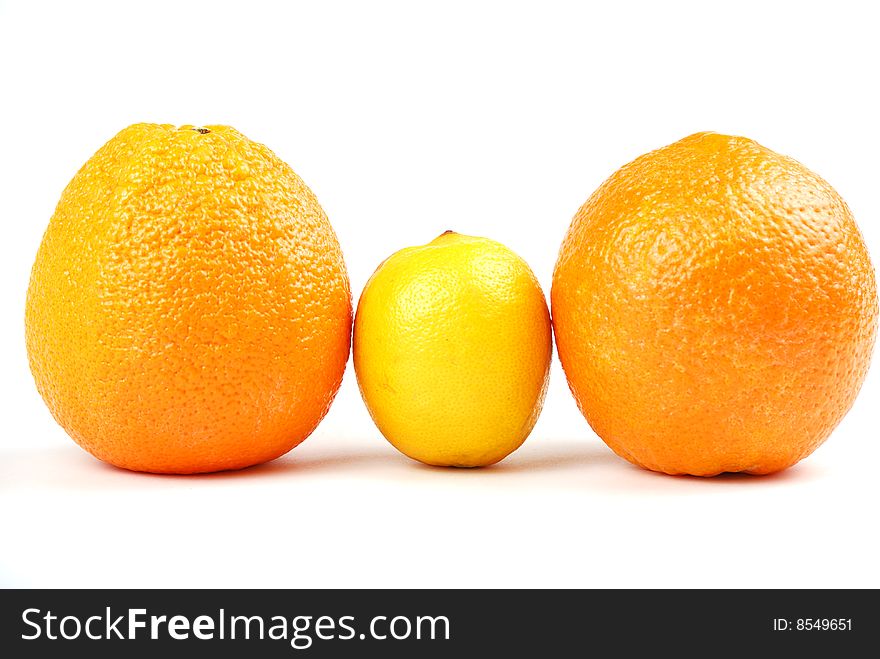 Two orange oranges and one yellow lemon between them.