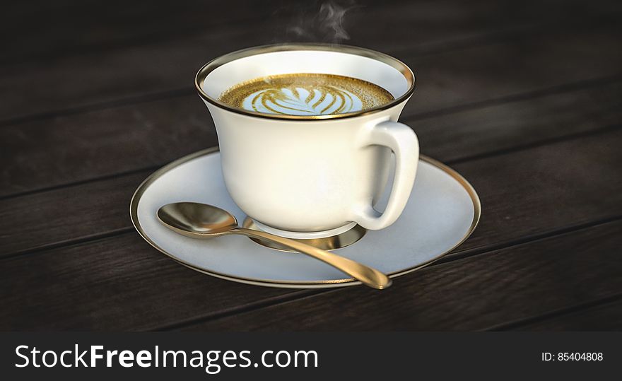 White Ceramic Mug Beside Gold Spoon