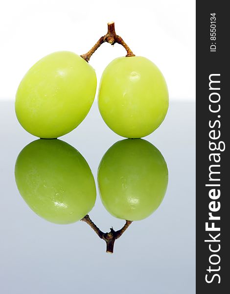 Close up of two green grapes isolated over white background.