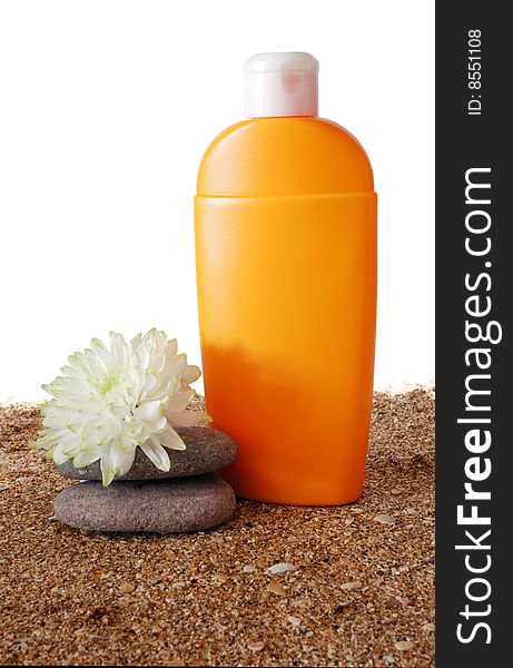 Antisun cream and flower on marine sand and white background