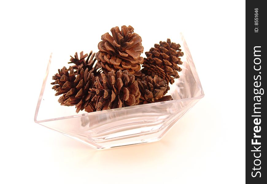 Pine cones in glass dish isolcated over solid background