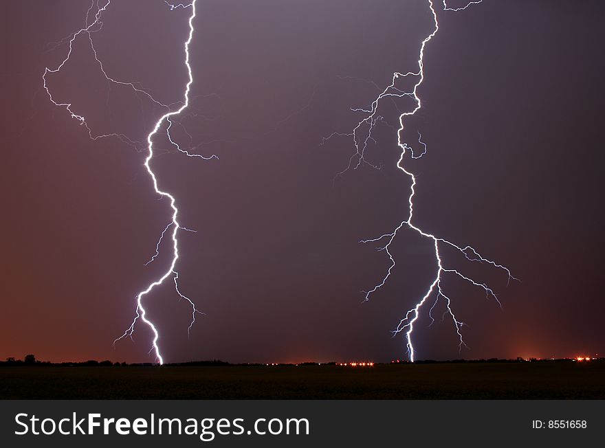 Two bolts of lightning light up the night sky. Two bolts of lightning light up the night sky.