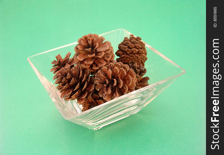 Pine cones in glass dish isolcated over solid background